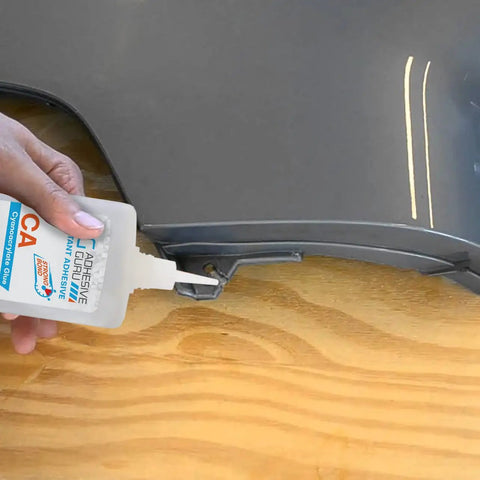 Applying Cyanoacrylate Glue With Activator Set Instant Grab CA Glue And Super Glue Accelerator on black plastic surface