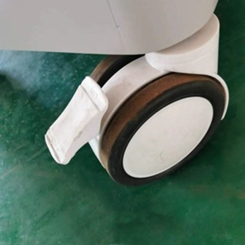 Badass Heavy Duty Trolley Casters Featuring Slick Polyurethane Wheels And Rock Solid Double Rotary Brakes For Furniture And Medical Equipment Rolling Smoothly close-up of swiveled caster with brake on a green surface.