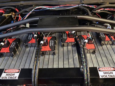 Professional Battery Management System Master Unit Managing Up To Eighteen Cells And Three Thermistors With Plug And Play Daisy Chaining And Weatherproof Can Bus Hookups For Domestic Ev Builds mounted on battery setup with wiring and labels.
