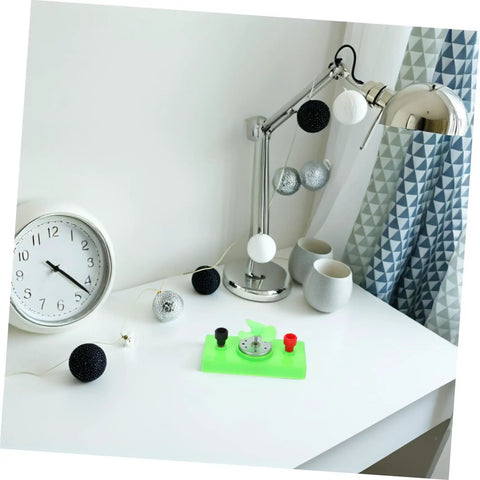 Desk setup with green DC motor DIY kit for mini wind turbine electric generator solar powered physics project for science experiments.