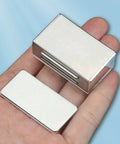 Hand holding No Drill Adhesive Magnetic Door Catch Set 17lb Holding Force For Kitchen Cabinets Cupboards And Drawers Self Stick Stainless Steel Latch 4 Pack Silver Damage Free Mounting