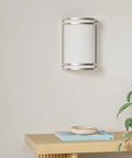 Kick Your Lighting Game Up Today With This Sleek Indoor LED Wall Sconce Sporting Brushed Nickel Finish And Adjustable 3000K 4000K 5000K Temps Plus Zero Hassle Mount And A Smooth Rust Proof Glow Built For Everyday Chill on wall with plant and book nearby.