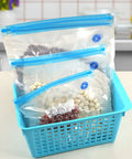 Handheld Vacuum Sealer For Food Storage Bags With T-Style Manual Pump. Space Saving compact design with sealed bags in a blue basket.