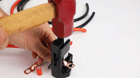 Hammer Lug Crimping Tool For 8 AWG Through 4 0 Battery And Welding Cables in use, crimping lug on a cable with red hammer