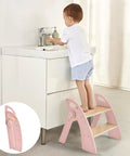 Child using Sturdy Wooden Two Step Stool For Kids Featuring Quick Fold Design And Rock Solid Base Perfect For Potty Training at bathroom sink.