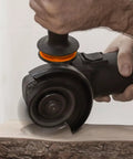 Hand using Knockout Turbo Scraper Wheel For Angle Grinders With Swivel Carbide Blades to plane raw lumber.