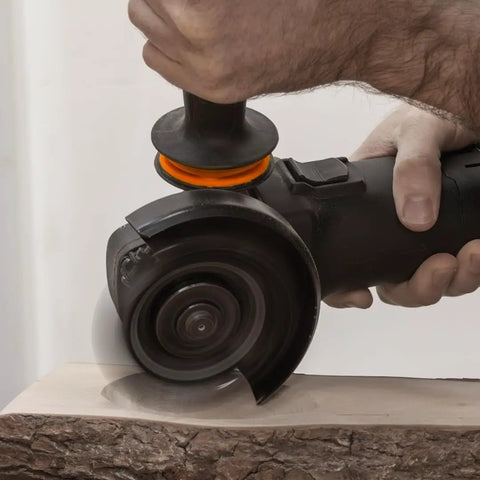 Hand using Knockout Turbo Scraper Wheel For Angle Grinders With Swivel Carbide Blades to plane raw lumber.