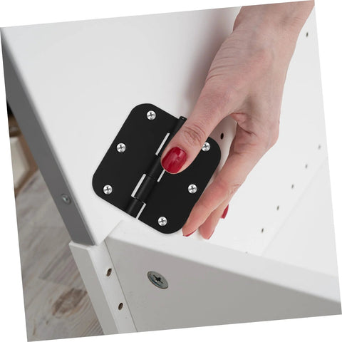 Close-up of a black rounded-corner iron door hinge mounted on a white cabinet door