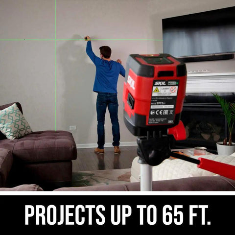 Man using 65 Ft Green Cross Line Laser Level With Self Leveling, USB Rechargeable Battery for precise wall alignment.