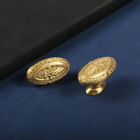 Antique Brass Cabinet Knobs 4 Pack Copper Oval Handles for Kitchen and Bathroom Cabinets placed on blue and black background