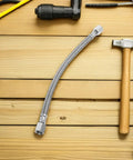 Heavy Duty Beefed Up Air Compressor Replacement Hose Kit with stainless steel tube on wooden surface with tools
