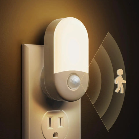 Close-up of 4 Pack Plug In Motion Sensor Night Light With 3000K Warm White, shown plugged into wall socket, sensing motion.