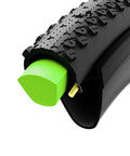 Cutaway view of a black tire with green Air-Liner Gravel Insert For Tubeless-Ready Bike Tires, Reusable Puncture-Proof Tire Insert For Gravel And MTB
