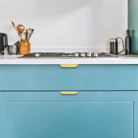 Premium Gold Cabinet Handles Finger Edge Pulls Sleek Brushed Finish on teal kitchen drawers with gas stove.