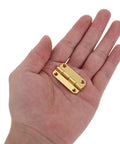 Close-up of hand holding one Vintage Small Iron Cabinet Hinges 12 Pack With Rounded Corners And Four Hole Vertical Design Antique Gold Finish