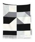 Black And White Piano Grid Winter Scarf Crafted From Plush Faux Cashmere With Extended Fringe Edges, stylish geometric design.