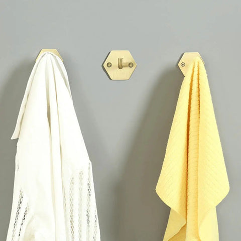 Top Shelf Brass Wall Hooks For Towels And Mugs No Sweat Rust Proof Bathroom Hanger holding white and yellow towels on wall.