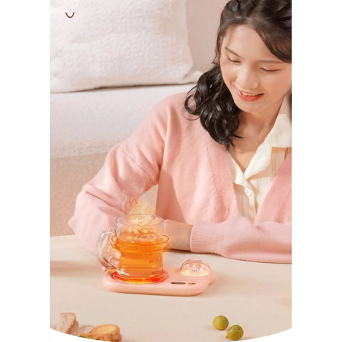 Portable Digital Cup Warmer With Three Heat Settings Hits The Spot Every Time Keeps Your Daily Brew Steaming Hot on a pink coaster with tea.