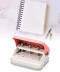 Ultimate Handheld 3-Hole Paper Puncher with 5-Sheet Capacity shown with notebook and pen on marble surface