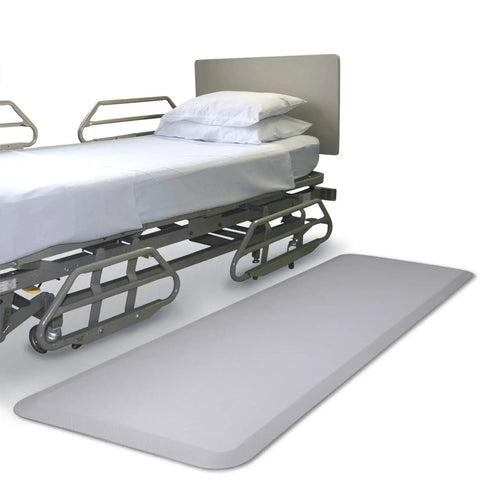 Ultimate 70 Inch Bedside Fall Mat For Elderly Safety beside hospital bed, non slip surface for injury prevention.