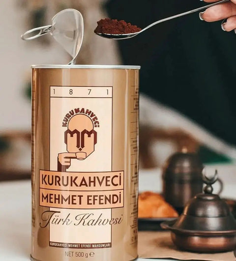 Can of Authentic Turkish Coffee From Mehmet Efendi Tradition, 100 Percent Arabica Ground Extra Fine For Cezve, Rich Aroma, Medium Roast, Classic Brew Since 1871, 17.6 Oz Bag with spoon and cezve in background