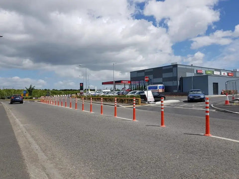 Heavy Duty Flexible Bollard Built Damn Tough For Busy Parking Lots Takes Serious Beating And Springs Back orange and white traffic barrier in use on road.