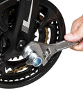 Hand using wrench on bike wheel from Six Piece Bicycle Repair Tools Kit For Mountain And Road Bikes, Pro Grade Cassette And Sprocket Removal Set
