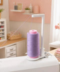 Heavy Duty Thread Spool Stand For Sewing Machines And Sweet White Cone Holder With Massive Capacity shown with lavender thread spool.