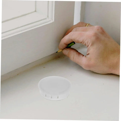 Round Plastic Hole Plugs 10 Pack For Furniture Quick Fix Cabinets Doors Walls Decorative Screw Covers Hide Holes Easy Install Durable Circle Hole Caps No Tools Needed visible next to hand marking measurement on surface.