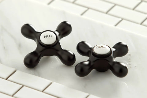 Heritage Widespread Lavatory Faucet In Oil Rubbed Bronze With Metal Cross Handles hot and cold knobs detail on white tiles