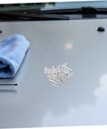 Grab 50 Durable Metal Panel Pulling Studs For Auto Body Work on a grey car hood, with a blue microfiber cloth nearby.