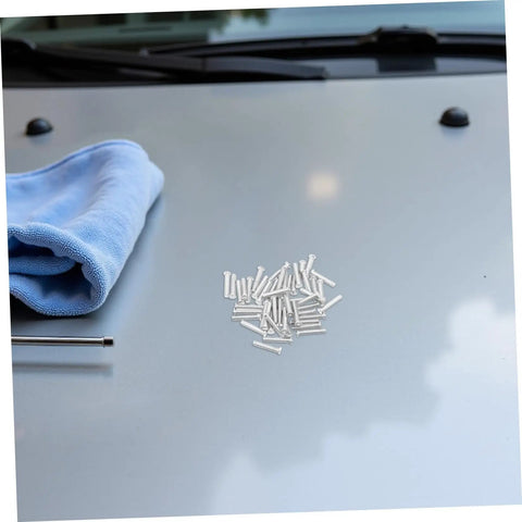 Grab 50 Durable Metal Panel Pulling Studs For Auto Body Work on a grey car hood, with a blue microfiber cloth nearby.
