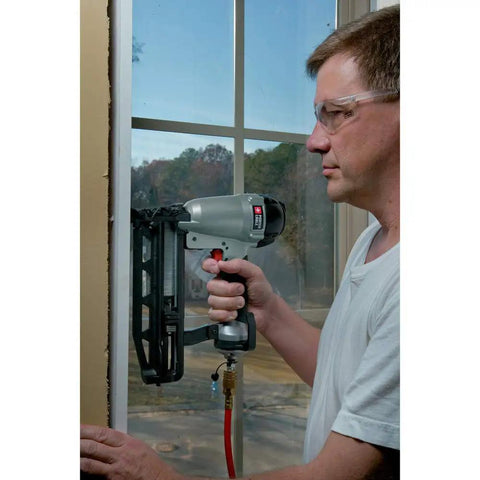 Person using 16-Gauge Straight Finish Nailer Kit With Tool-Free Depth-Of-Drive Adjustment, Jam Release, And Durable Motor for window trim