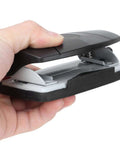 Hand holding a compact 2 Hole Puncher With Positioning Ruler Mini Handheld Black Office Tool for school, non-slip bottom visible.