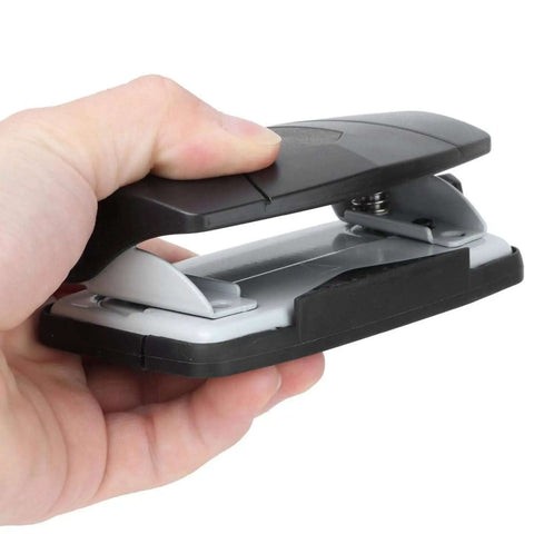 Hand holding a compact 2 Hole Puncher With Positioning Ruler Mini Handheld Black Office Tool for school, non-slip bottom visible.