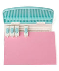 Top view of Word Punch Board For Scrapbooking And Card Making Dope Letter Punch Set With 26 Letters punching 'HAPY' on pink paper.