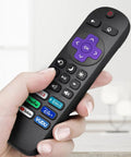 Hand holding Roku TV remote replacement with purple controls, six shortcut keys, part of Four Pack Replacement TV Remote For Roku TV.