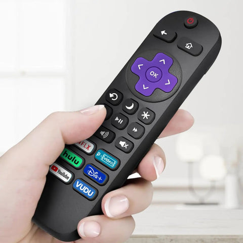 Hand holding Roku TV remote replacement with purple controls, six shortcut keys, part of Four Pack Replacement TV Remote For Roku TV.