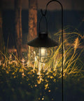 Solar Lantern Outdoor Hanging Light, Metal Solar Lamp With Warm White Edison Bulb illuminating garden, black finish at night