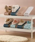 Double Deck Vertical Shoe Slot Organizer With Adjustable Two Tier Design showing assorted shoes on a white shelving unit.