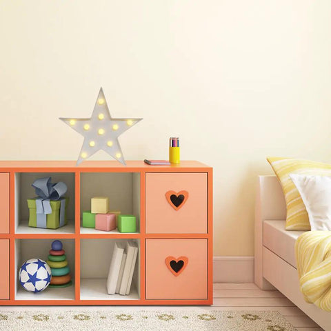 Star Shaped LED Marquee Light With 11 Warm White LEDs on orange shelf in cozy bedroom setting.