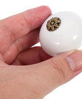 Hand holding Two Pack Single Hole Dresser Handles For Cabinets And Drawers White Antique Round Door Knobs for Wardrobes
