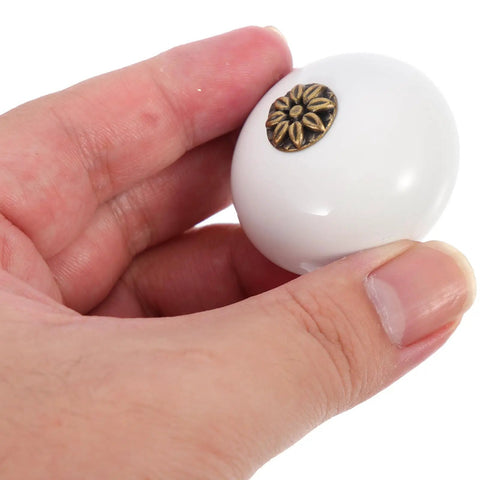 Hand holding Two Pack Single Hole Dresser Handles For Cabinets And Drawers White Antique Round Door Knobs for Wardrobes