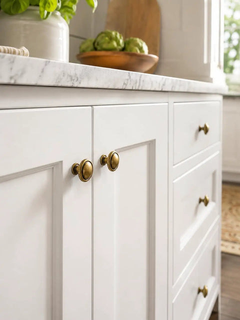 Top Shelf Antique Brass Cabinet Knobs Six Pack Round Single Hole Kitchen Furniture Hardware Easy DIY Install Vintage Inspired aged brass knobs on a white kitchen cabinet.