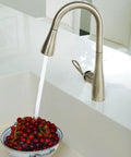 High Arc Pulldown Bar Faucet With One Handle Chrome Finish, Reflex Technology in use rinsing a bowl of berries in a kitchen sink