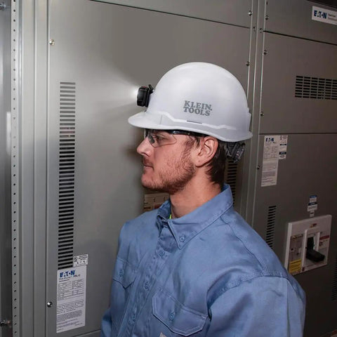 Worker wearing a non-vented cap style hard hat with padded odor-resistant self-wicking sweatband and front headlamp mount