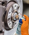 Mechanic's Aid 17-6 Penetrating Oil Low Viscosity Formula That Loosens Stubborn Nuts And Bolts And Removes Rust With Molybdenum Corrosion Inhibitors 11 Oz Can 50 State Compliant being sprayed onto a wheel hub by an orange-gloved hand