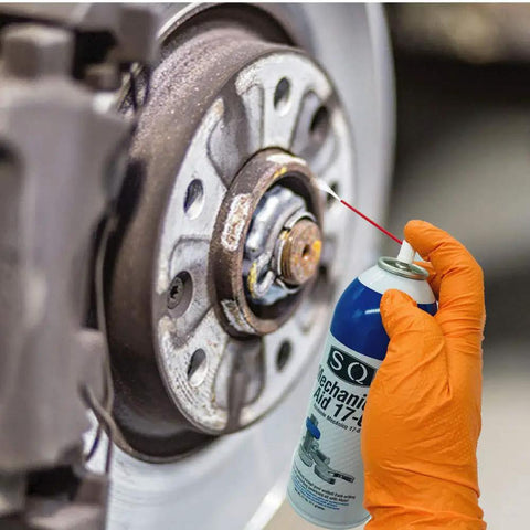 Mechanic's Aid 17-6 Penetrating Oil Low Viscosity Formula That Loosens Stubborn Nuts And Bolts And Removes Rust With Molybdenum Corrosion Inhibitors 11 Oz Can 50 State Compliant being sprayed onto a wheel hub by an orange-gloved hand