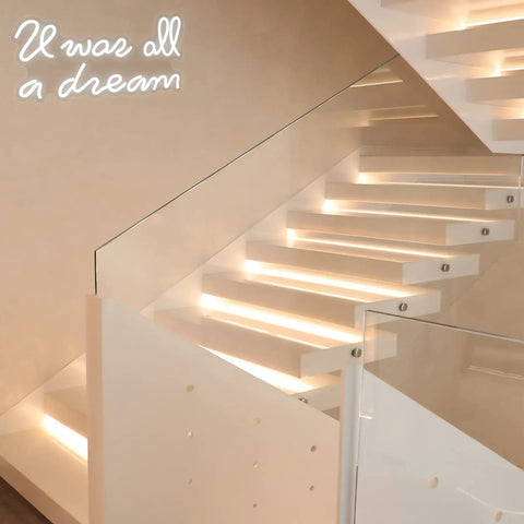 Modern staircase with glass railing and 'U was all a dream' neon sign on wall; interior decor featuring ambient lighting.