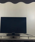 Super Cool Vintage Style One Light Wall Sconce With Clear Glass Shade And Metal Base In Chrome flanking a TV in an alcove
